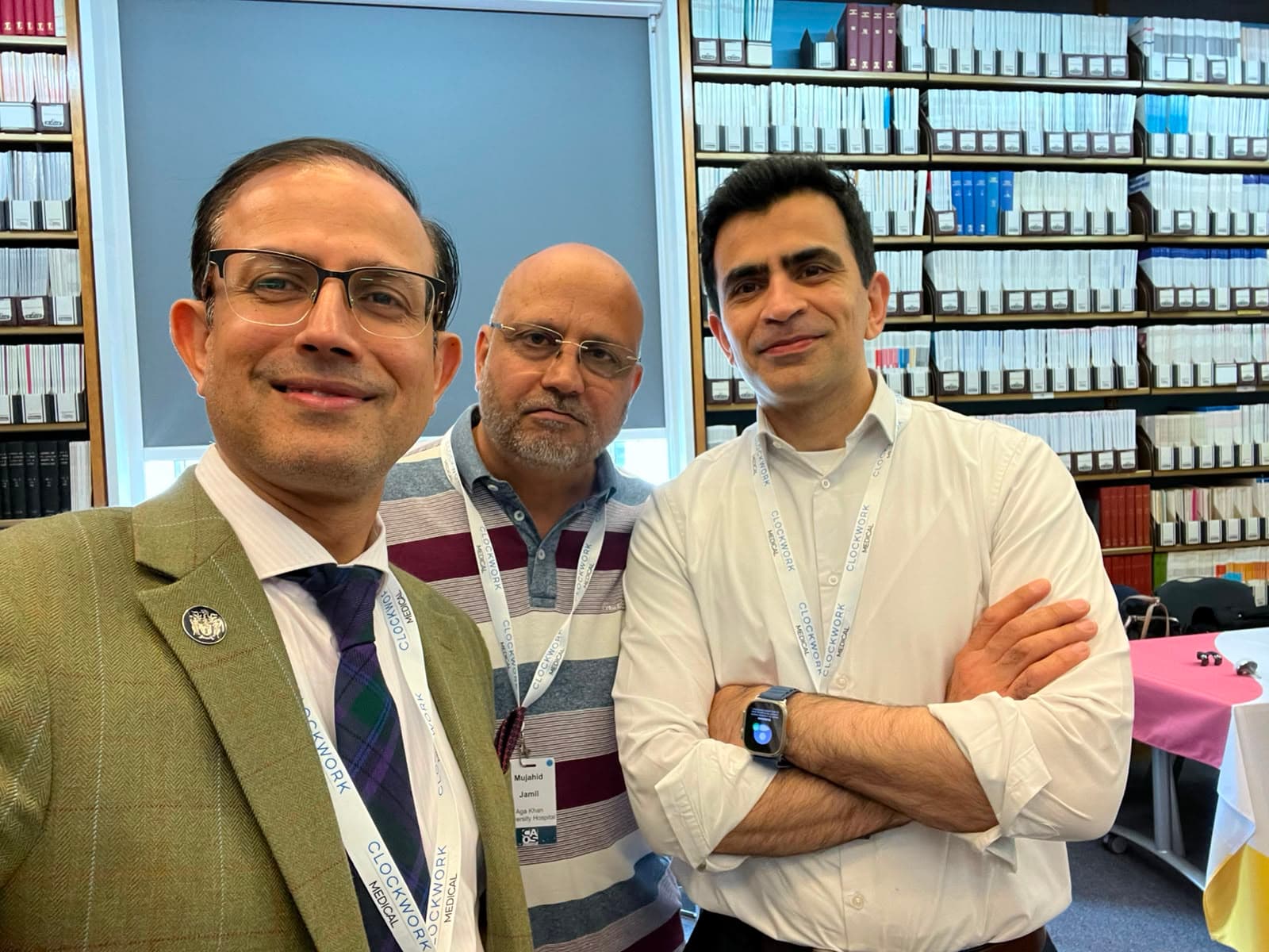 Dr Mujahid Jamil Khattak alongside two colleagues in the library at the Computer Assisted Orthopaedic Surgery Meeting 2026 in London