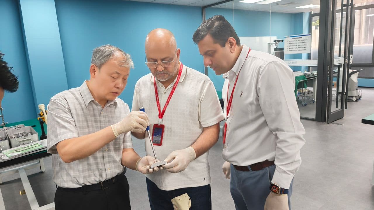 Dr Mujahid Jamil Khattak examining a knee implant and surgical instrumentation in the training lab during the seminar in China