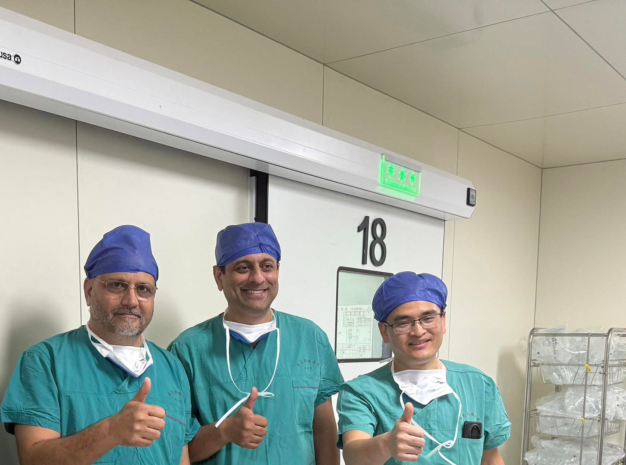 Dr Mujahid Jamil Khattak with fellow surgeons in scrubs outside the operating theatre during the robotic knee replacement faculty visit in China