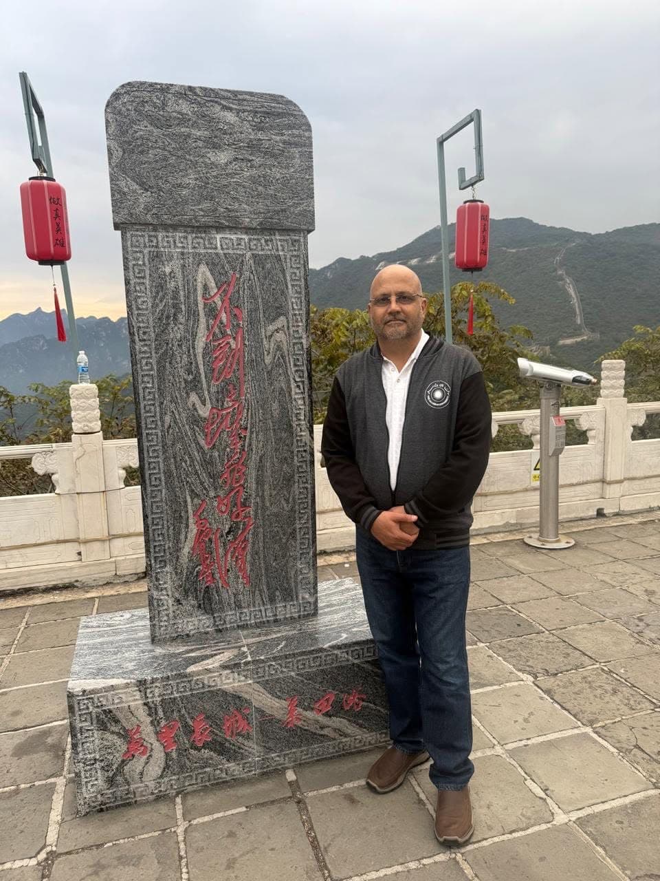 Dr Mujahid Jamil Khattak beside a traditional Chinese stone monument at a mountain viewpoint during the faculty visit to China